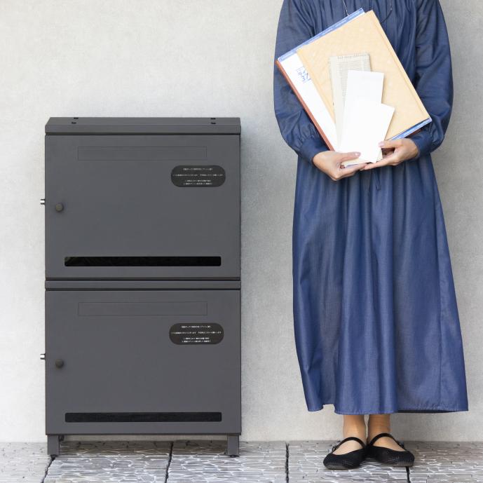 黒いロッカーと書類を持つ女性